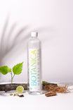 Botanica herbal water bottle with leaves and herbs on a white background